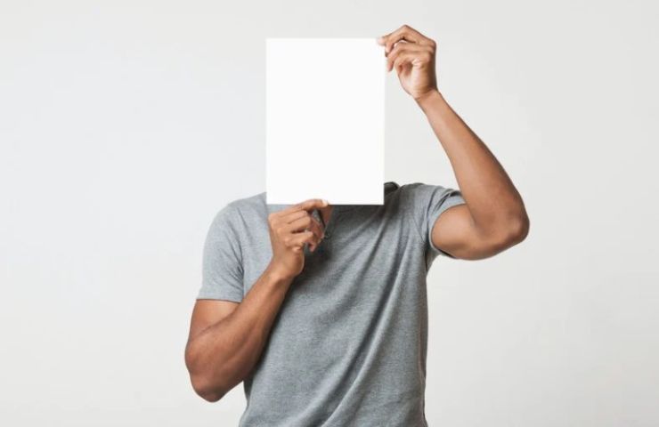 persona con un foglio davanti al viso