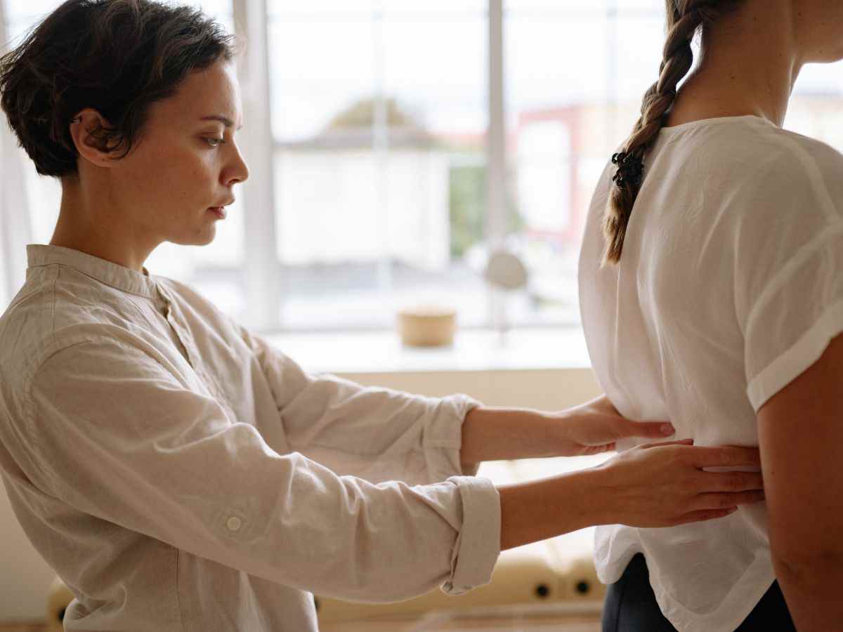 fisioterapista tocca schiena a paziente