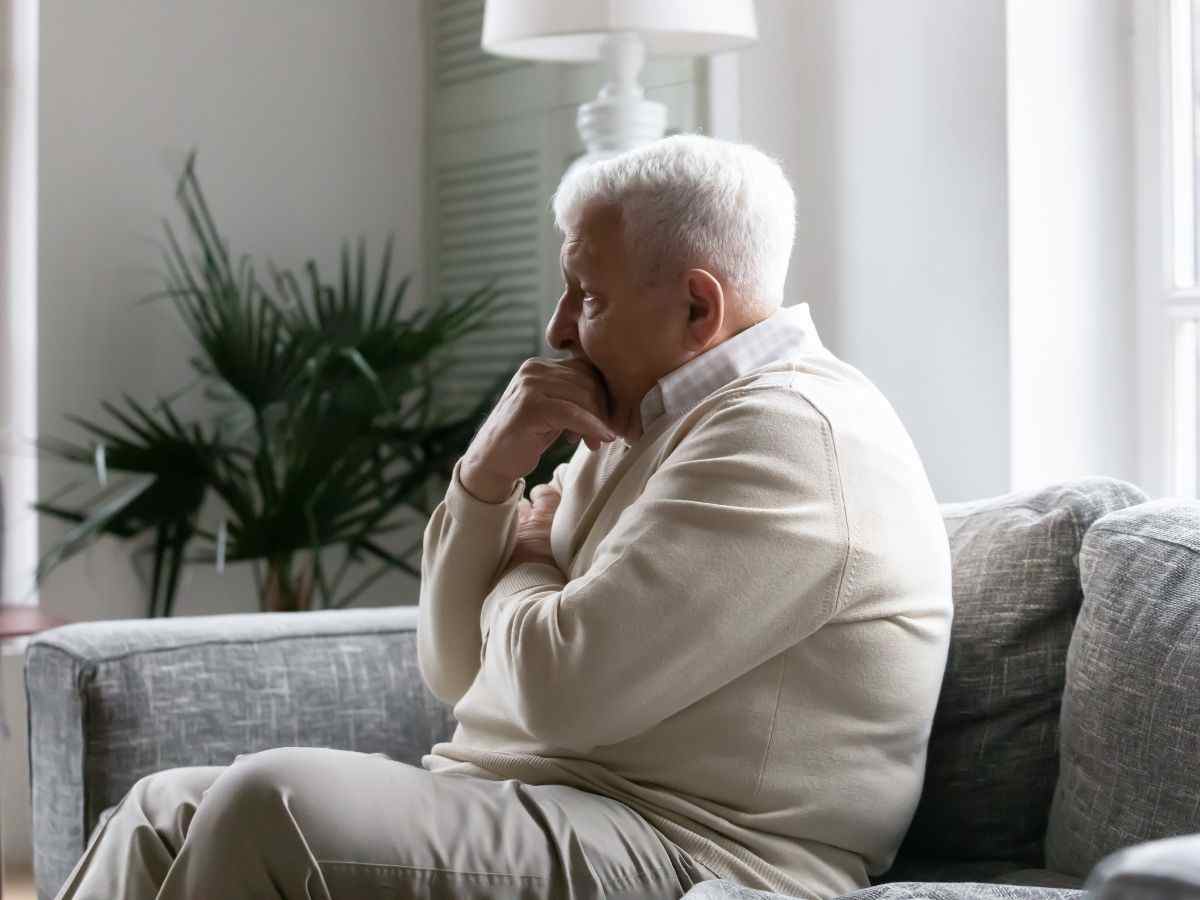 uomo anziano su un divano preoccupato