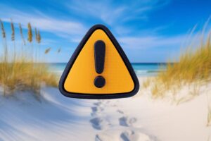 spiaggia bianca e segnale di pericolo